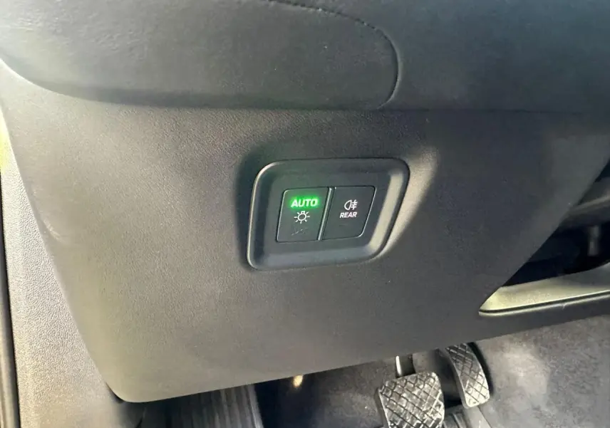 Détail des commandes d’éclairage avec bouton auto allumé sur Porsche Cayenne 2024, intérieur côté conducteur.