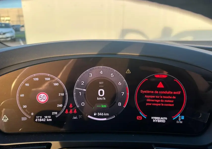Tableau de bord numérique du Porsche Cayenne hybride 2024, affichant 0 km/h et alertes système en rouge.