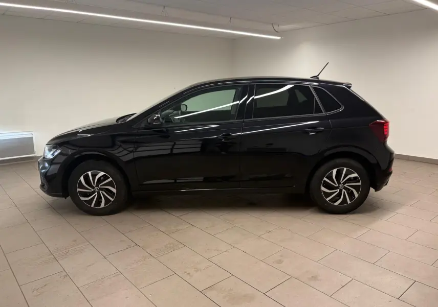 Vue de profil côté gauche d'une Volkswagen Polo noire intense 2025 dans un intérieur neutre, avec jantes alliage 15 pouces.