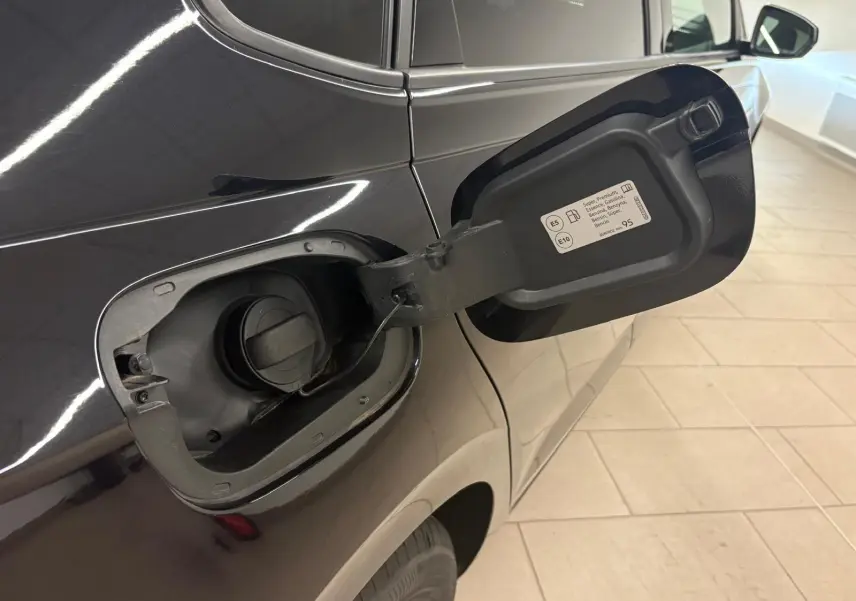 Vue rapprochée du côté gauche arrière d'une Volkswagen Polo noire intense avec trappe à carburant ouverte.