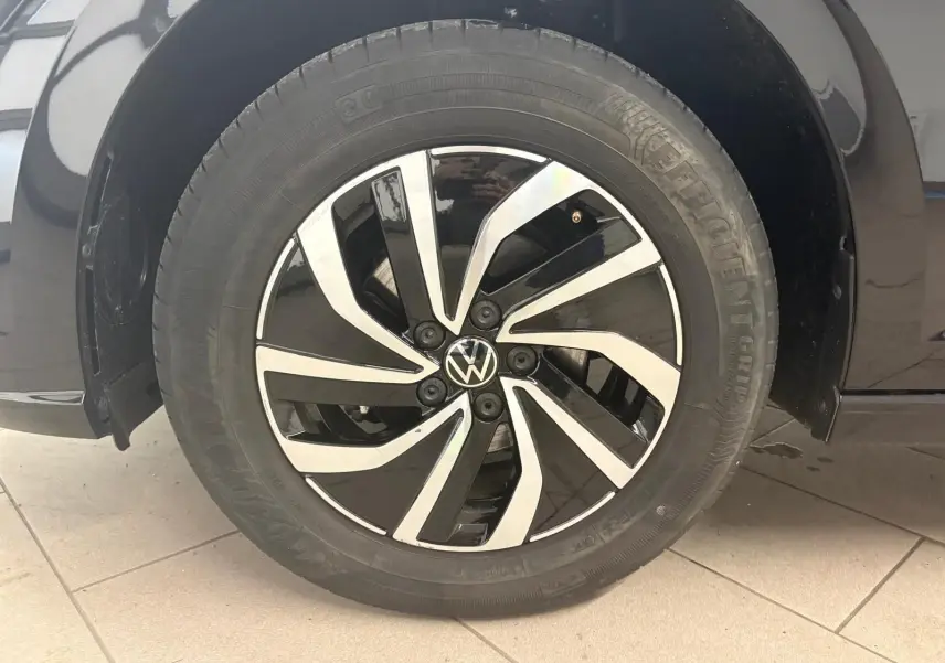 Gros plan sur la jante alliage bicolore noire et argentée d'une Volkswagen Polo noire intense, côté droit.