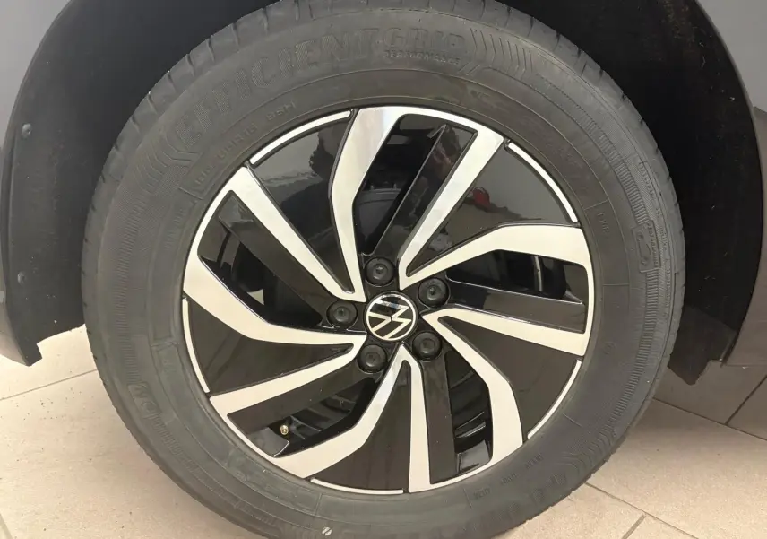 Gros plan sur la jante alliage bicolore noire et argentée avec logo Volkswagen au centre, montée sur un pneu Goodyear.