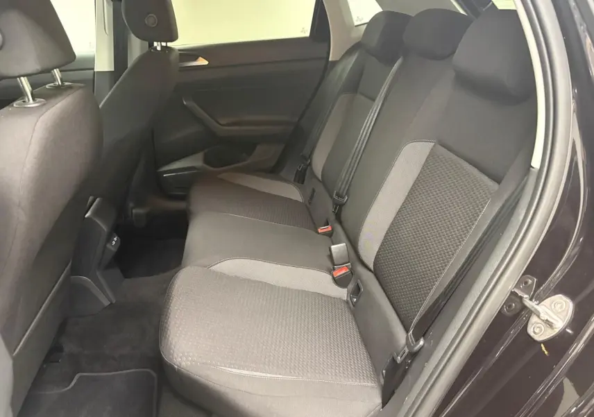Vue intérieure côté droit de la banquette arrière noire et grise de la Volkswagen Polo 2025 avec ceintures de sécurité visibles.