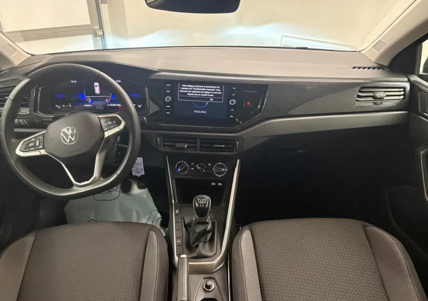 Vue intérieure avant de la Volkswagen Polo noire intense 2025, volant cuir multifonctions et tableau de bord digital.