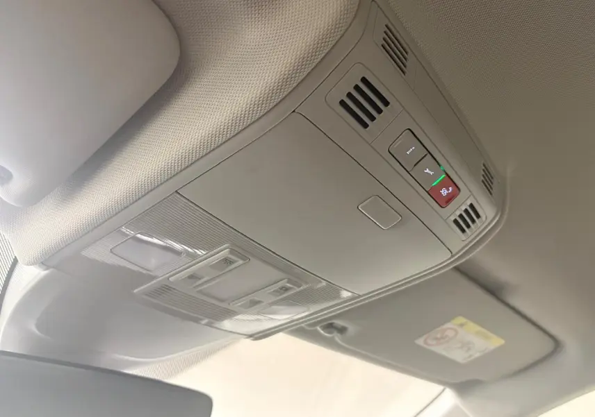 Vue intérieure du plafonnier beige avec commandes d’éclairage et bouton d’appel d’urgence dans une Volkswagen Polo noire.