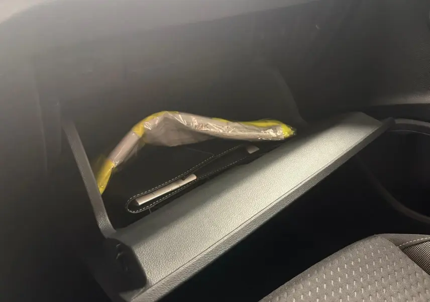 Vue intérieure du vide-poche passager de la Volkswagen Polo 2025 noir intense avec notice emballée visible.