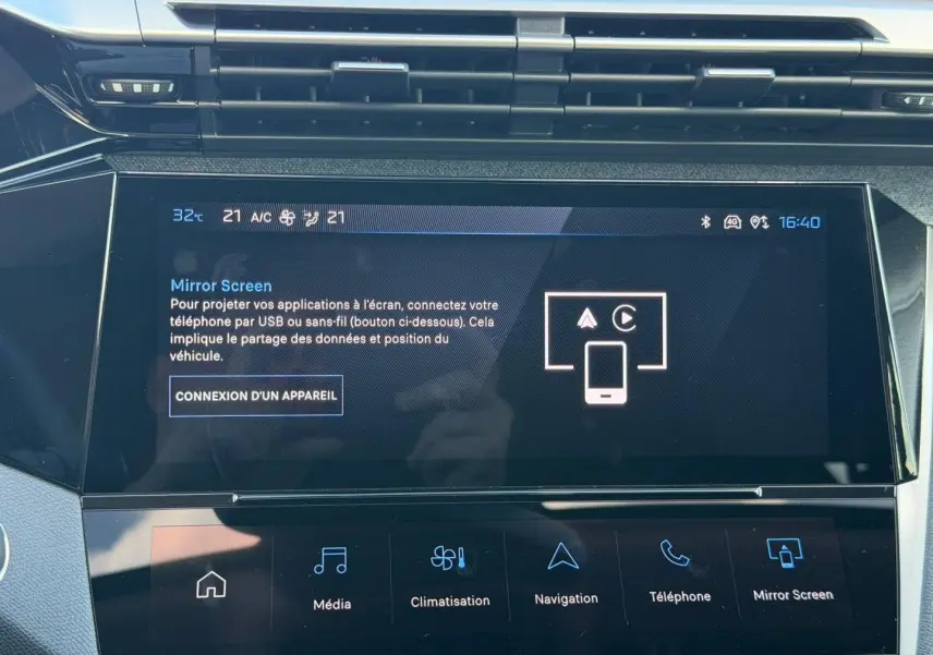 Gros plan sur l'écran tactile central de la Peugeot 308 rouge Elixir, affichant le menu Mirror Screen.