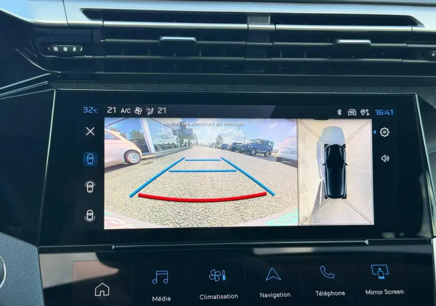 Écran tactile intérieur de la Peugeot 308 rouge Elixir montrant la caméra de recul et l’aide au stationnement.