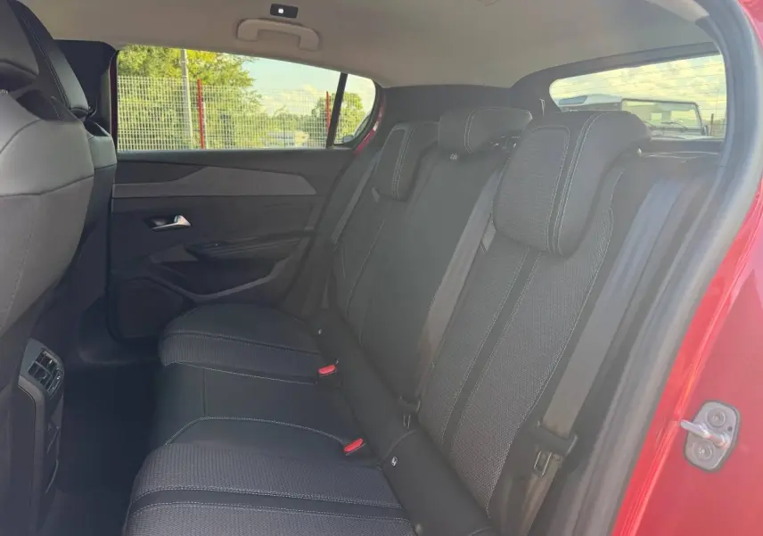 Vue côté droit de la banquette arrière noire avec surpiqûres blanches dans Peugeot 308 rouge Elixir 2025.