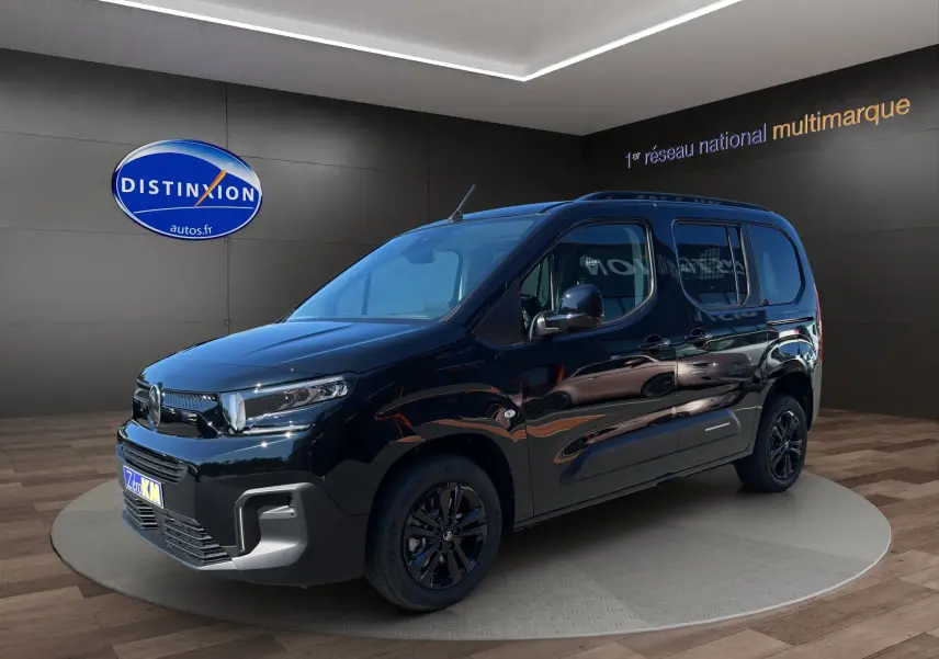 Vue 3/4 avant droit d'un Citroën Berlingo noir 2025 avec jantes alliage noires et barres de toit.