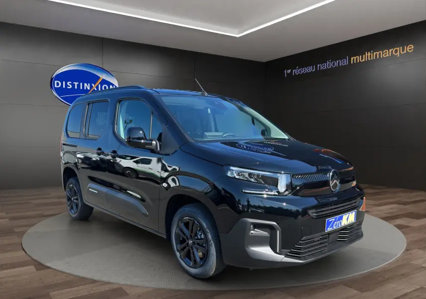 Vue 3/4 avant droite du Citroën Berlingo noir avec jantes alliage noires et calandre moderne en showroom.