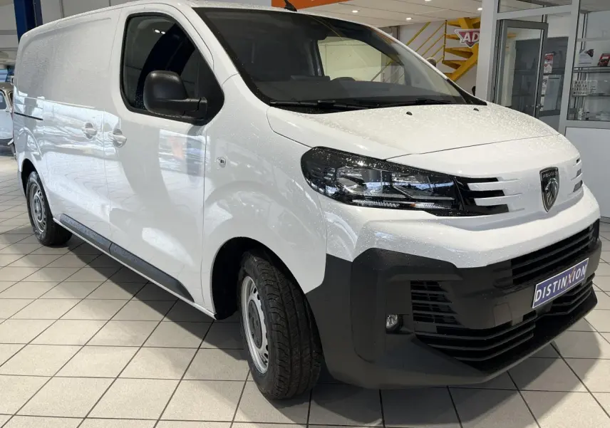 Peugeot Expert Fourgon blanc en 3/4 avant droit, avec boucliers noirs et roues tôles grises en showroom.