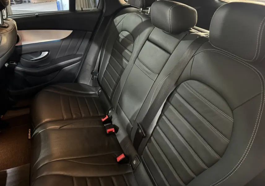 Vue intérieure côté droit des sièges arrière en cuir noir du Mercedes GLC 250 Fascination 2019 avec ceintures visibles.