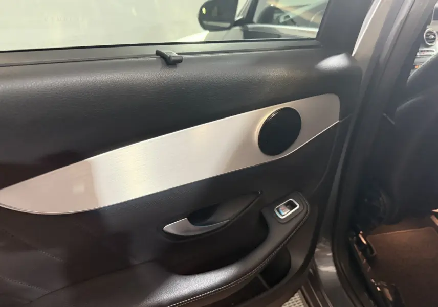 Détail de la porte arrière gauche intérieure du Mercedes GLC 250 Fascination 2019 avec garniture noire et insert aluminium.