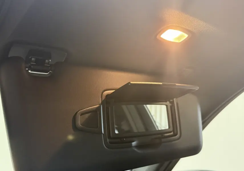 Détail du pare-soleil côté conducteur avec miroir éclairé dans un Mercedes GLC 250 Fascination gris foncé, vue intérieure.