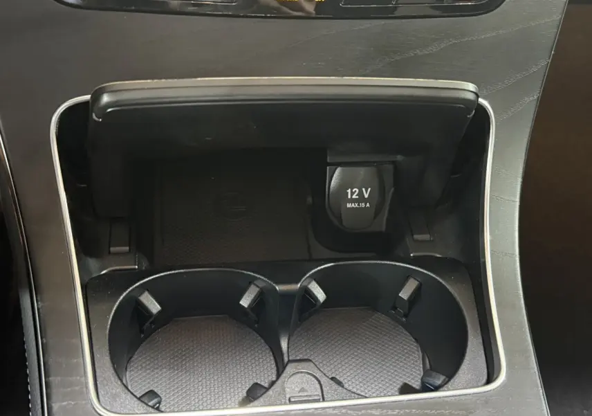 Gros plan sur la console centrale noire du Mercedes GLC 250 Fascination 2019 avec prise 12V et porte-gobelets.