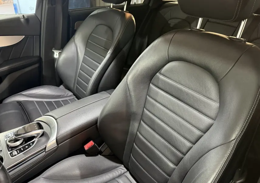 Gros plan sur les sièges avant en cuir noir et la console centrale d’une Mercedes GLC 250 Fascination 2019.