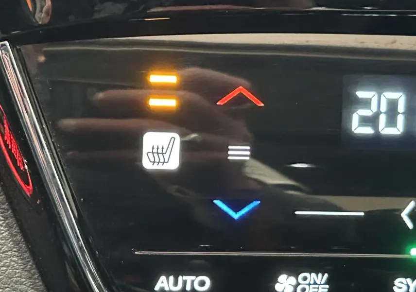 Détail du tableau de bord du Honda HR-V bleu 2020 montrant la commande du siège chauffant et la température réglée à 20°C.