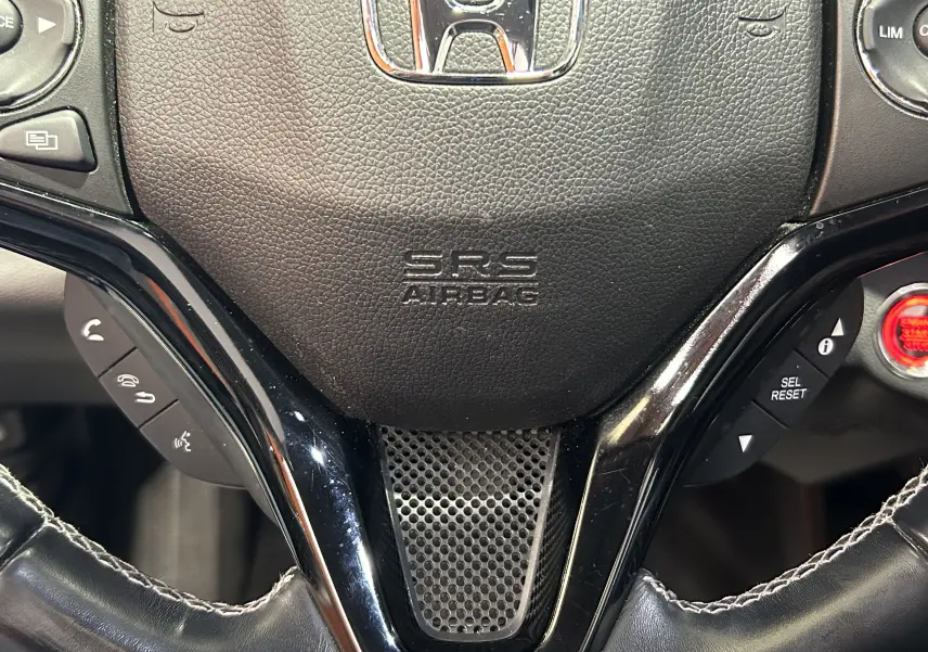 Gros plan sur le volant en cuir noir du Honda HR-V 2020, avec commandes intégrées et logo Honda visible.