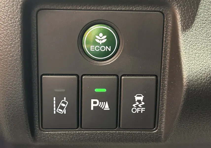 Gros plan sur les boutons de commande du tableau de bord du Honda HR-V 2020, avec bouton ECON vert et indicateurs d'aide à la conduite.