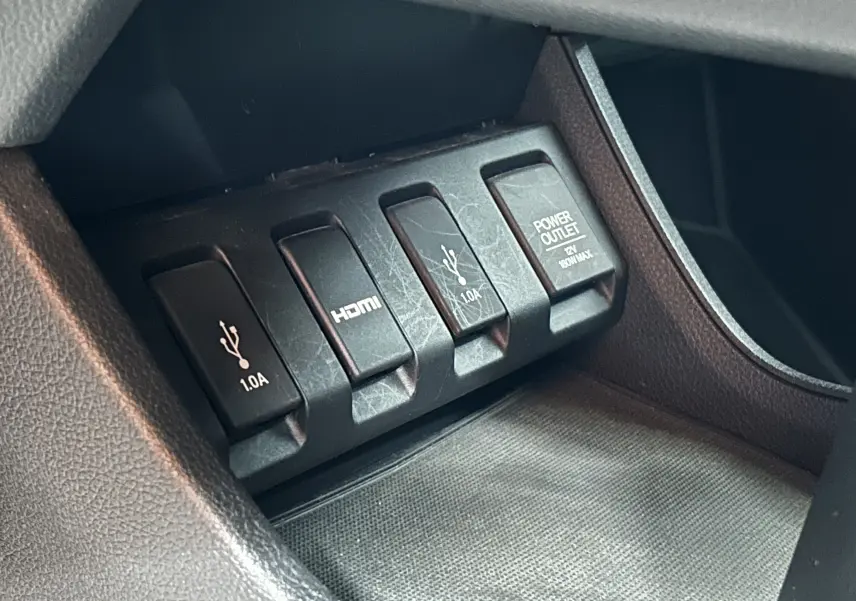 Gros plan sur les ports USB, HDMI et prise 12V du Honda HR-V i-VTEC 130ch Exclusive 2020, intérieur noir.