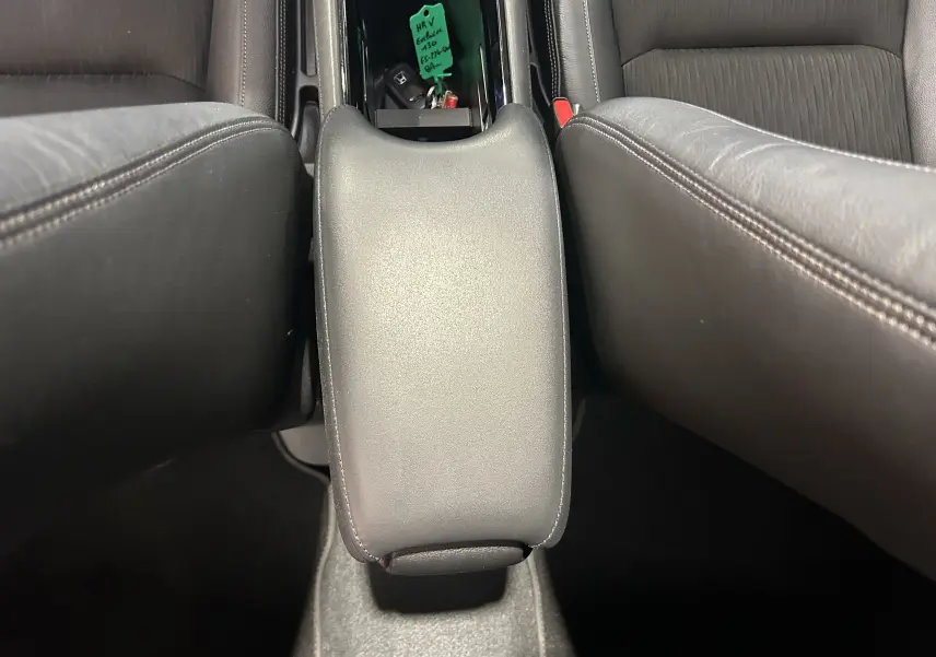 Vue rapprochée de l'accoudoir central en cuir noir entre les sièges avant du Honda HR-V bleu 2020.