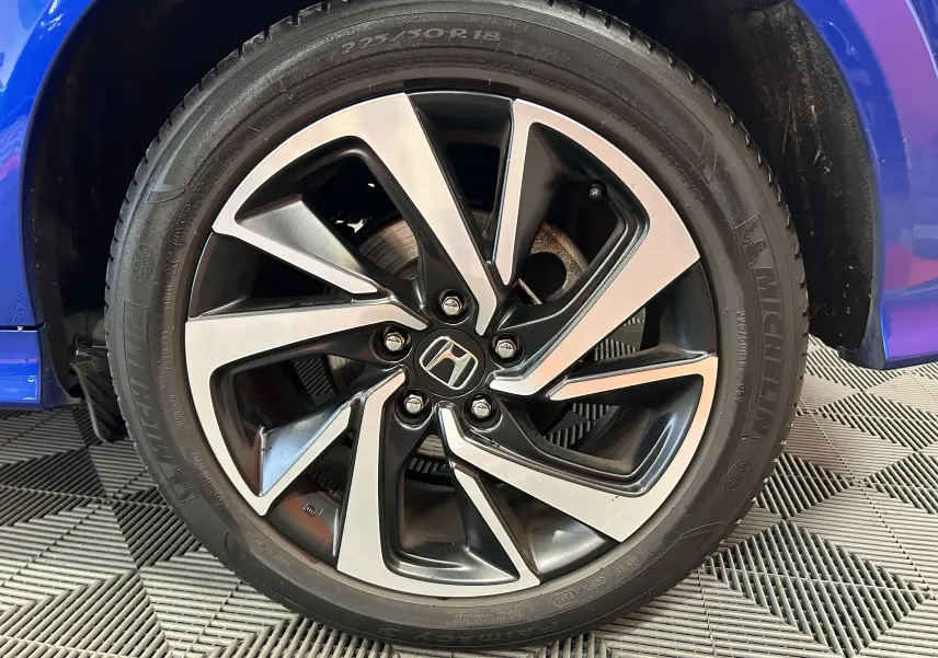 Gros plan sur la jante alliage bicolore d’un Honda HR-V bleu, mettant en valeur le logo Honda au centre.