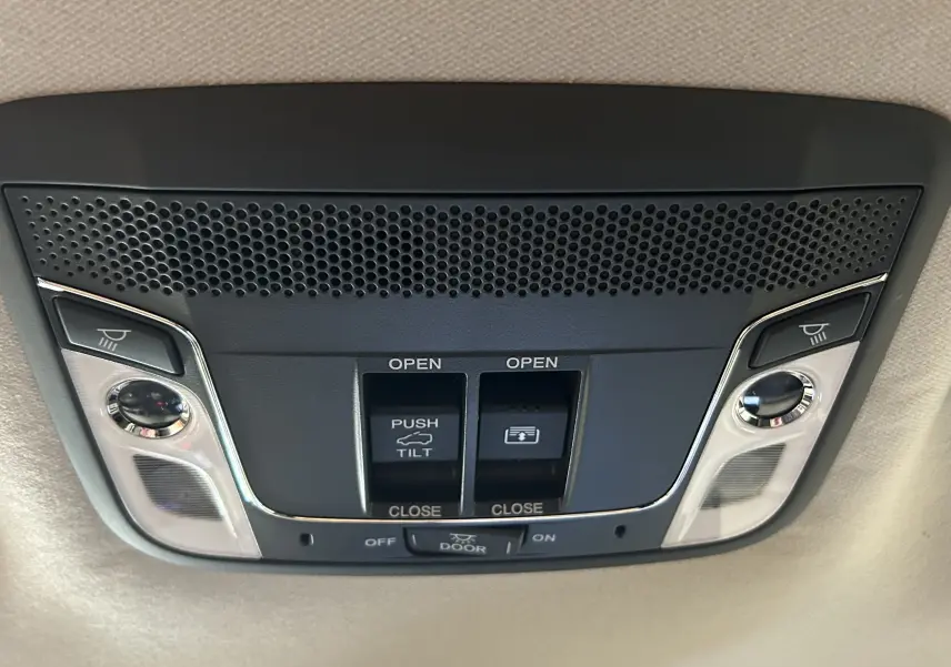 Vue en gros plan du panneau de commande du toit ouvrant avec boutons d'ouverture et éclairage intérieur du Honda HR-V bleu 2020.