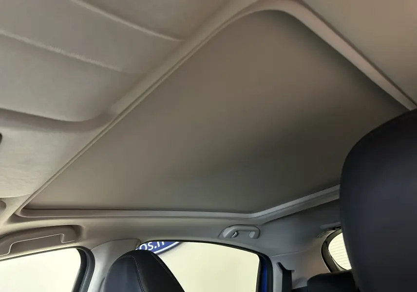 Vue intérieure du toit ouvrant fermé du Honda HR-V bleu, avec sièges avant en cuir noir visibles de côté droit.