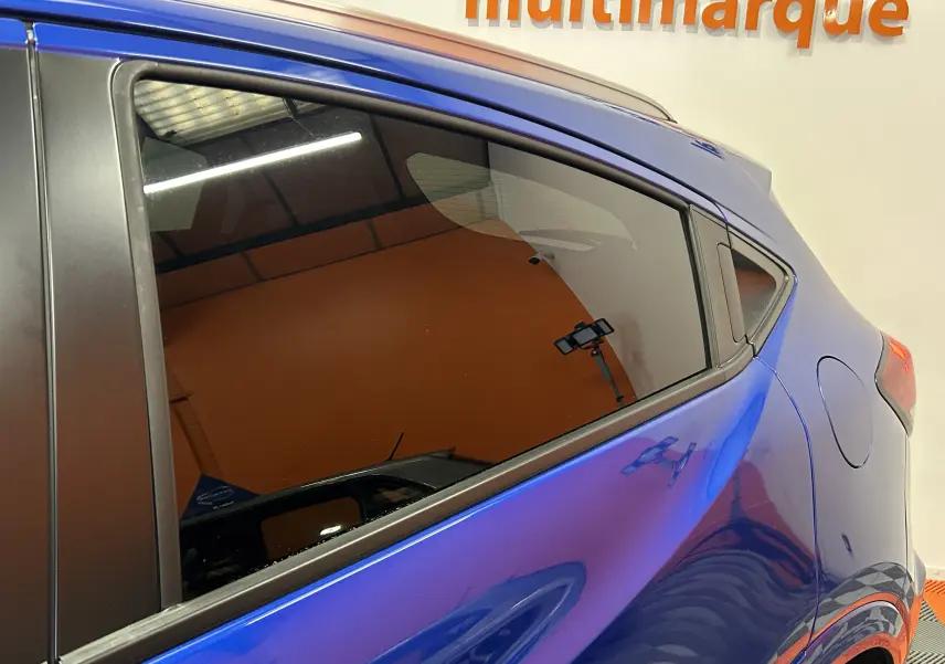 Vue latérale arrière droite du Honda HR-V bleu avec vitres teintées et toit ouvrant visible en partie.