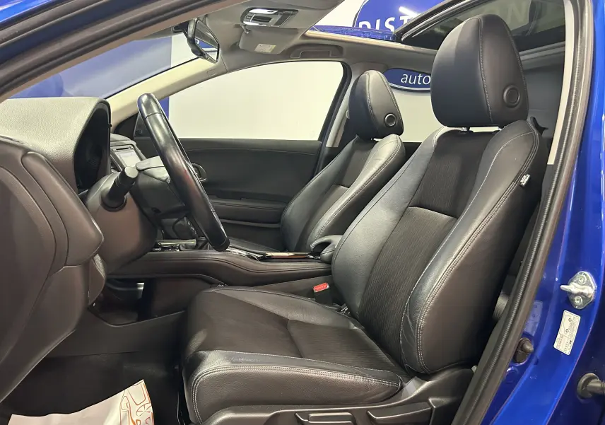 Vue intérieure côté conducteur du Honda HR-V bleu 2020, sièges cuir noirs et toit ouvrant visible.