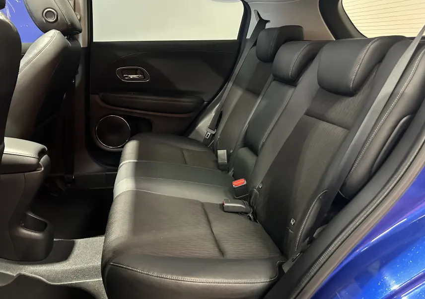 Vue intérieure côté droit des sièges arrière en cuir noir du Honda HR-V bleu, avec portière ouverte.