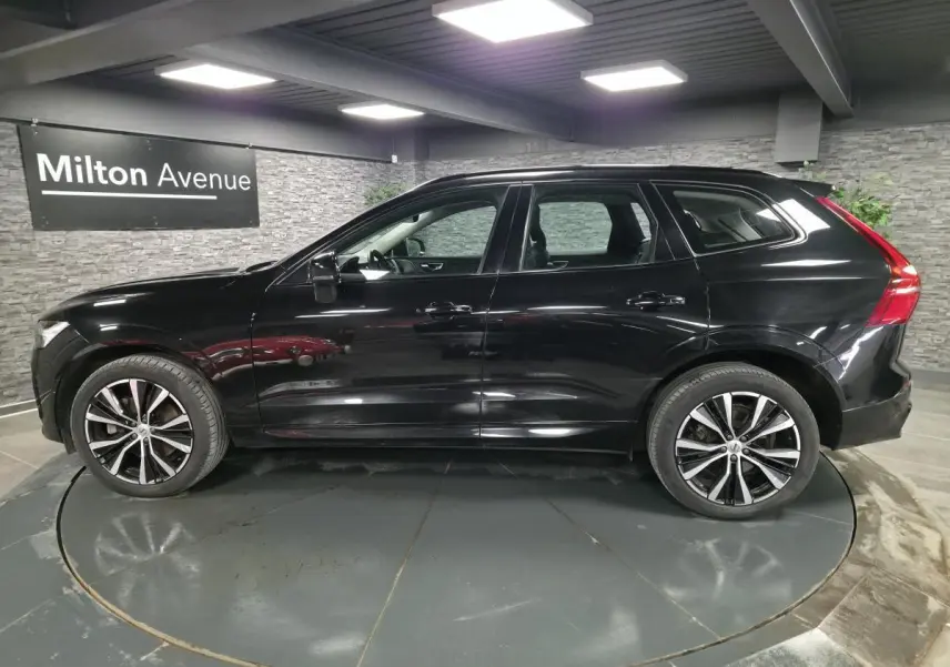 Vue de profil côté gauche d'un Volvo XC60 noir métallisé avec jantes alliage 20 pouces en Y noir et diamant.