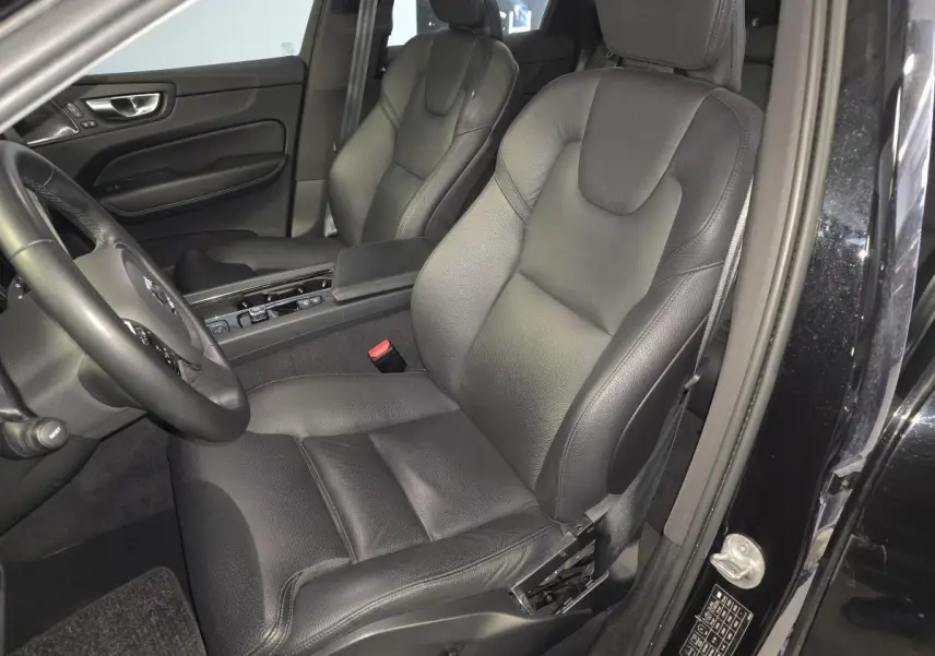 Vue intérieure côté conducteur du Volvo XC60 noir 2023, sièges cuir noirs et console centrale visible.