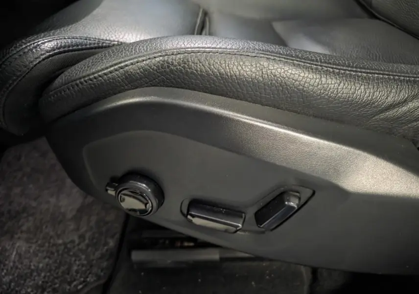 Détail des commandes de réglage électrique du siège avant en cuir noir du Volvo XC60 2023.