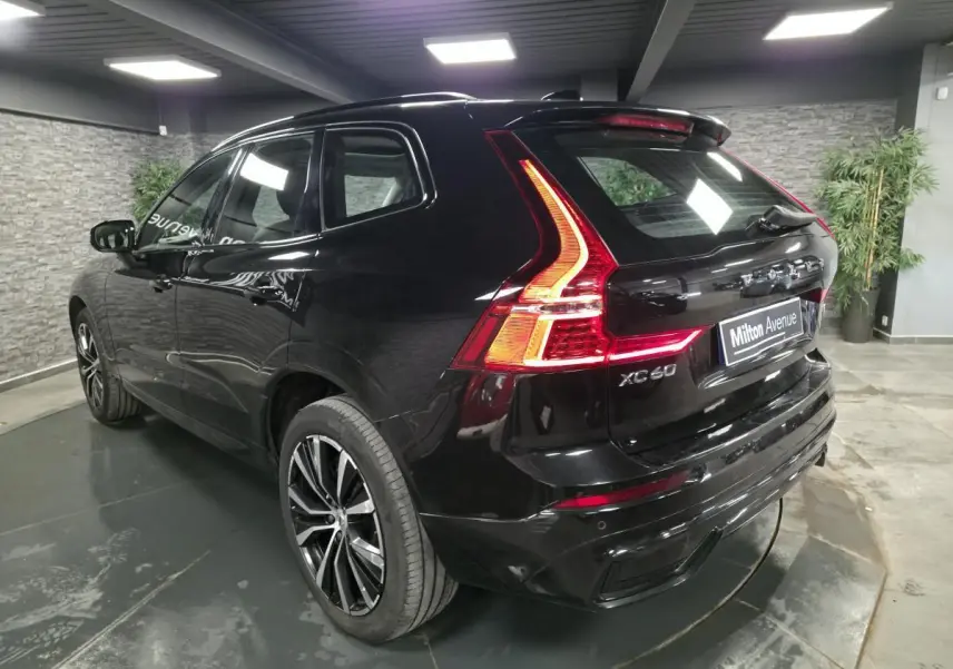 Vue 3/4 arrière droite du Volvo XC60 noir avec feux arrière LED et jantes alliage 20 pouces en Y.
