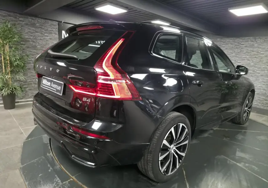 Vue 3/4 arrière droite du Volvo XC60 B4 micro-hybride diesel noir métallisé avec jantes alliage 20 pouces et feux LED distinctifs.
