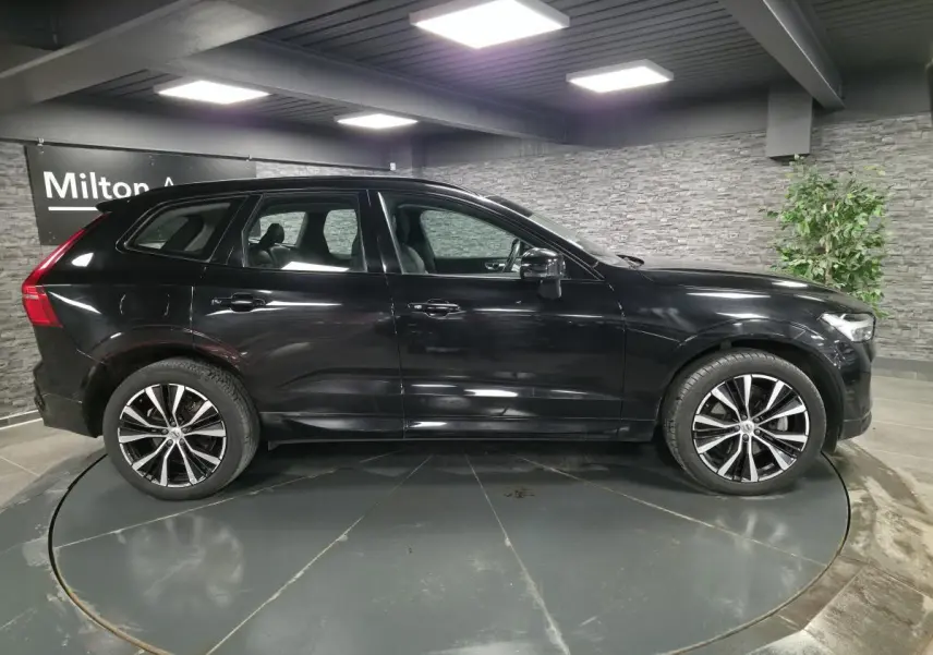 Vue latérale droite d'un Volvo XC60 noir métallisé avec jantes alliage 20 pouces en Y noir et diamant.