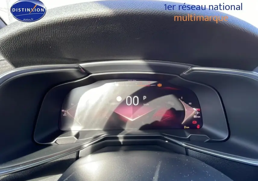 Vue rapprochée du tableau de bord numérique du DS7 bleu, affichant la vitesse à 0 km/h et indicateurs lumineux.
