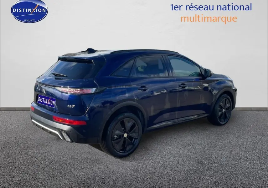 Vue 3/4 arrière droite d'un DS7 bleu foncé avec jantes noires et vitres arrière surteintées.