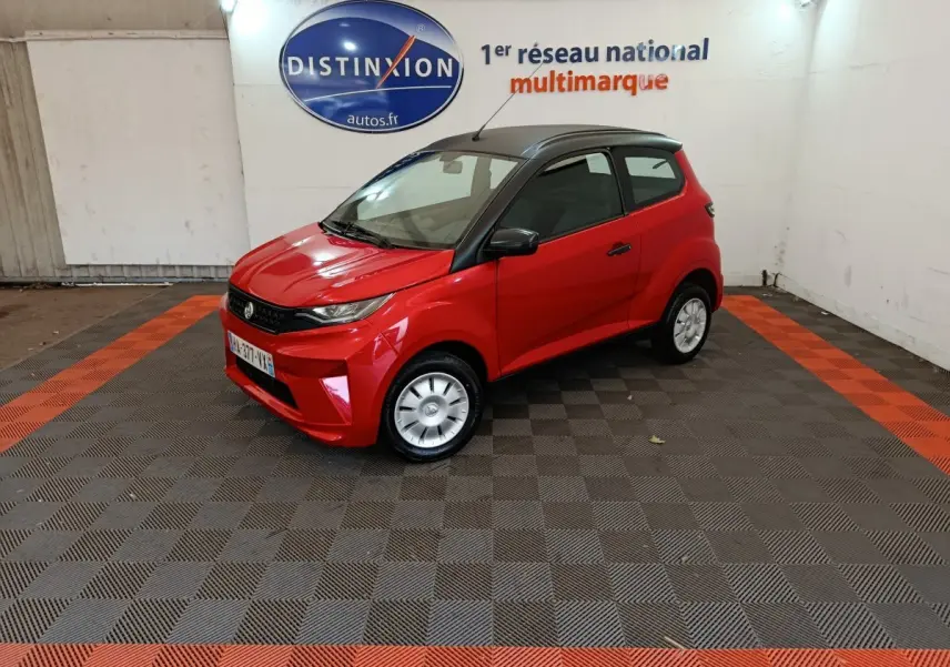 Vue 3/4 avant droite d'une Aixam Ambition 0.5 City Crossline Pack rouge avec toit noir et rétroviseur côté conducteur.
