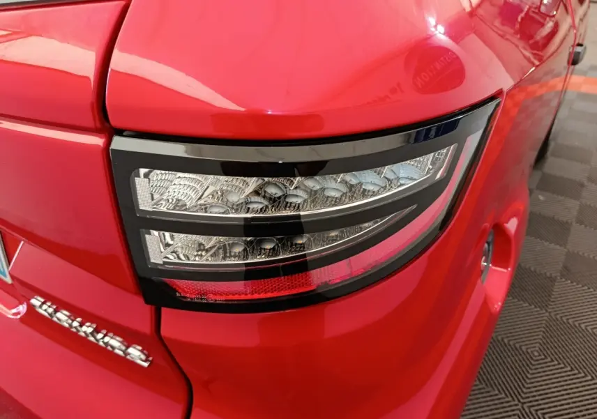 Gros plan sur le feu arrière droit rouge d'une Aixam Ambition 0.5 City Crossline Pack 2024 avec détails LED.