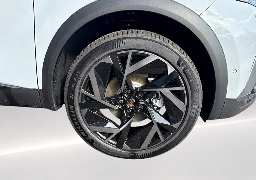 Gros plan sur la roue avant droite avec jante alu noire au design géométrique du Renault Symbioz gris rafale.