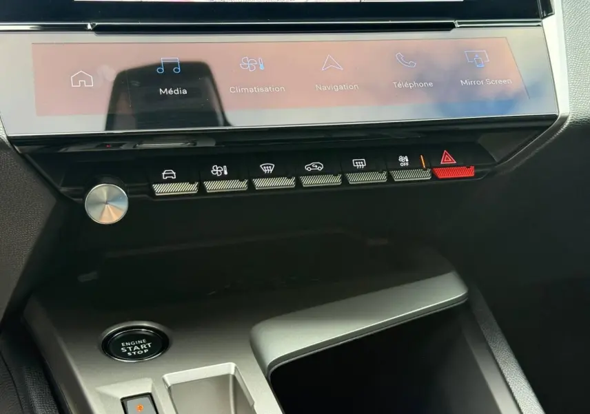 Gros plan sur la console centrale de la Peugeot 308 SW rouge, avec écran tactile et boutons de commande.
