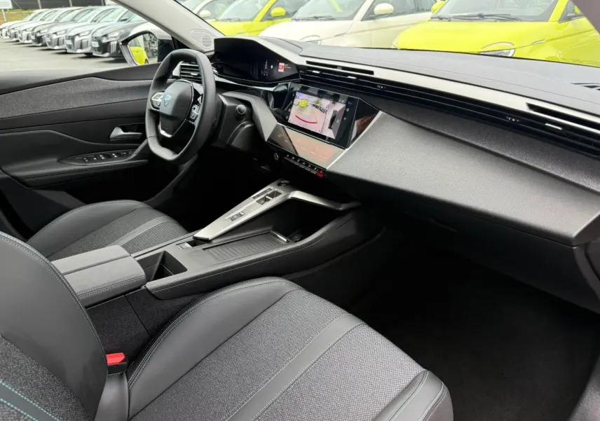 Vue intérieure côté conducteur de la Peugeot 308 SW 2025 avec tableau de bord moderne et écran tactile.