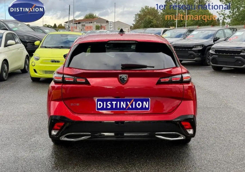 Vue arrière d'une Peugeot 308 SW rouge Elixir avec feux LED et double sortie d'échappement chromée.