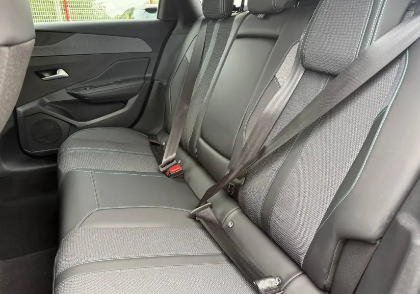 Vue côté gauche de la banquette arrière en tissu et cuir noir avec ceintures attachées du Peugeot 308 SW 2025.