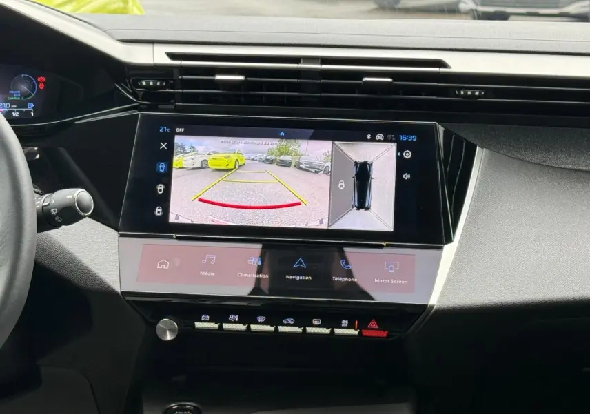 Vue intérieure du tableau de bord de la Peugeot 308 SW 2025 avec écran tactile affichant la caméra de recul et les commandes multimédia.