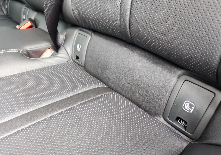Gros plan sur la banquette arrière en cuir noir perforé du Mazda CX-60 2024 avec ancrages ISOFIX visibles.