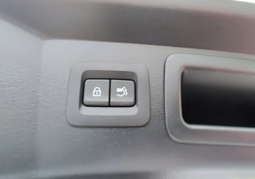 Gros plan sur les boutons de verrouillage et ouverture du hayon intérieur d'un Mazda CX-60 blanc métal 2024.